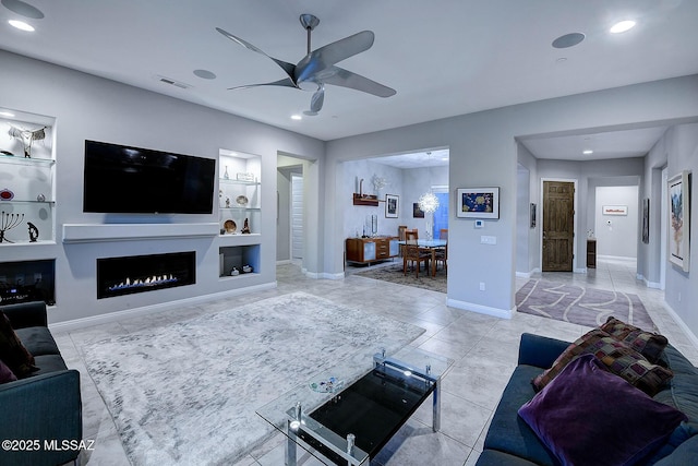 living room featuring ceiling fan and built in shelves