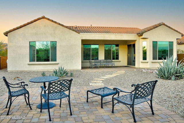 back house at dusk with a patio