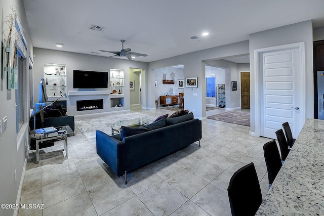 tiled living room featuring ceiling fan