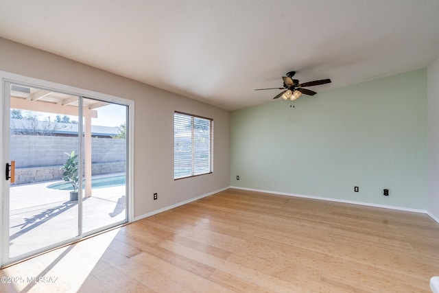 empty room with ceiling fan and light hardwood / wood-style flooring