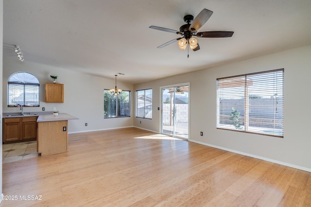 living room featuring sink, ceiling fan with notable chandelier, and light hardwood / wood-style floors