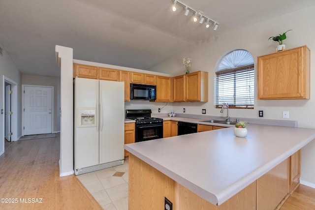 kitchen with sink, vaulted ceiling, black appliances, and kitchen peninsula