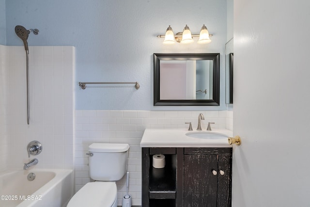 full bathroom with tile walls, vanity, washtub / shower combination, and toilet