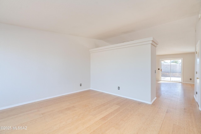 spare room featuring light hardwood / wood-style floors and vaulted ceiling