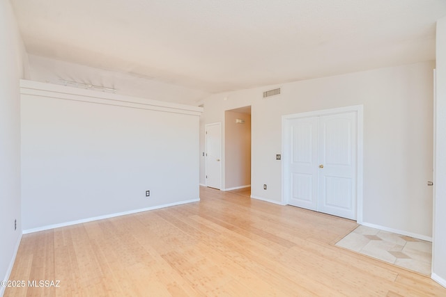 unfurnished room with lofted ceiling and light hardwood / wood-style floors