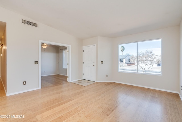 empty room featuring lofted ceiling, light wood-type flooring, and ceiling fan