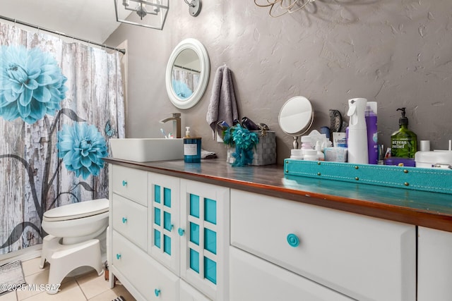 bathroom with toilet, vanity, a chandelier, and tile patterned flooring