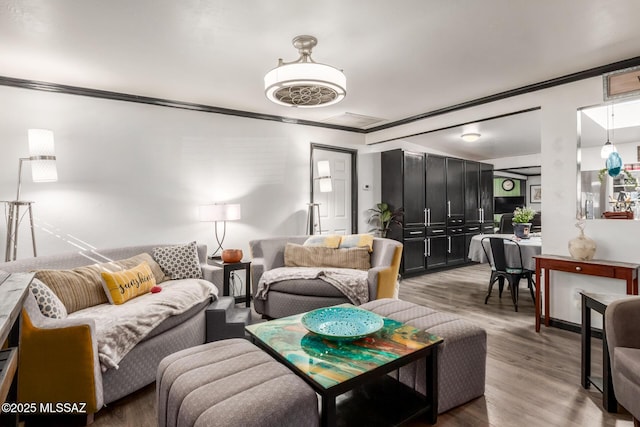 living room featuring wood-type flooring and crown molding