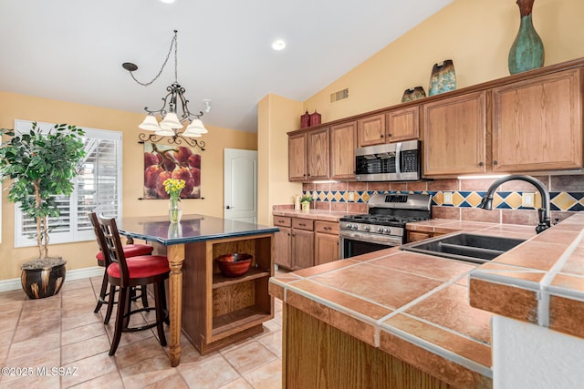 kitchen with appliances with stainless steel finishes, backsplash, lofted ceiling, and sink