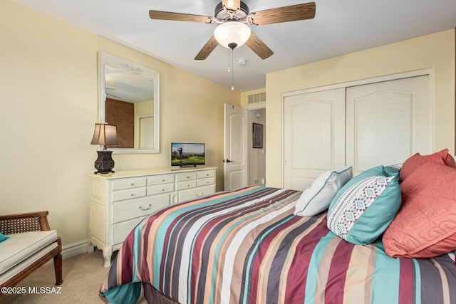 bedroom featuring ceiling fan, a closet, and light colored carpet