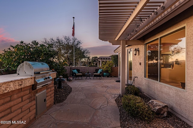 patio terrace at dusk with area for grilling and a grill