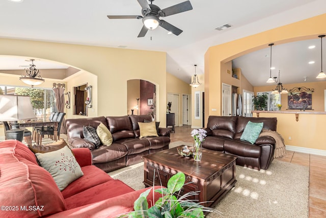 living room with light tile patterned floors, lofted ceiling, ceiling fan, and a healthy amount of sunlight