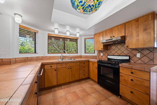 kitchen with tile countertops, plenty of natural light, sink, and black electric range