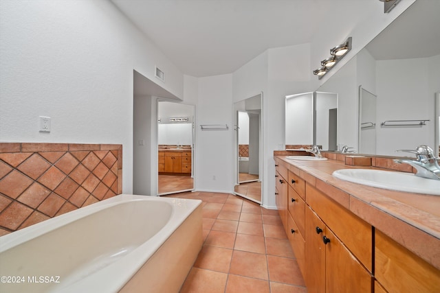 bathroom with tile patterned floors, vanity, and a bath