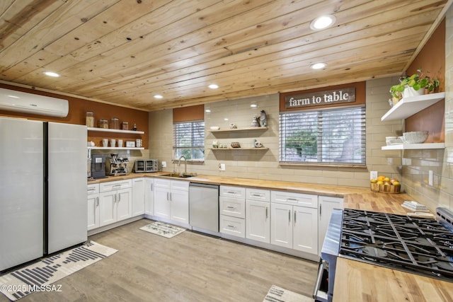 kitchen featuring stainless steel appliances, butcher block counters, a wall unit AC, and open shelves