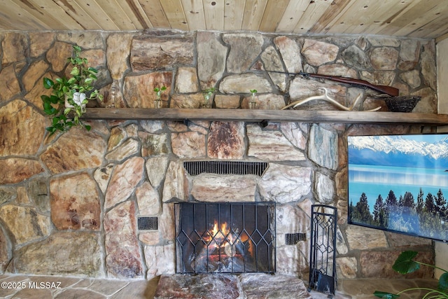 interior details featuring a stone fireplace and wooden ceiling