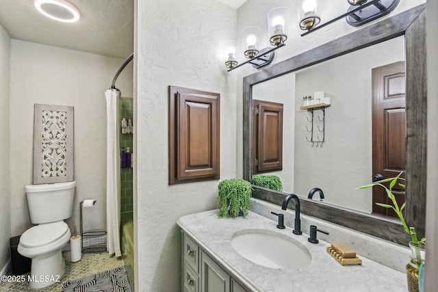 bathroom featuring toilet, curtained shower, a textured wall, and vanity