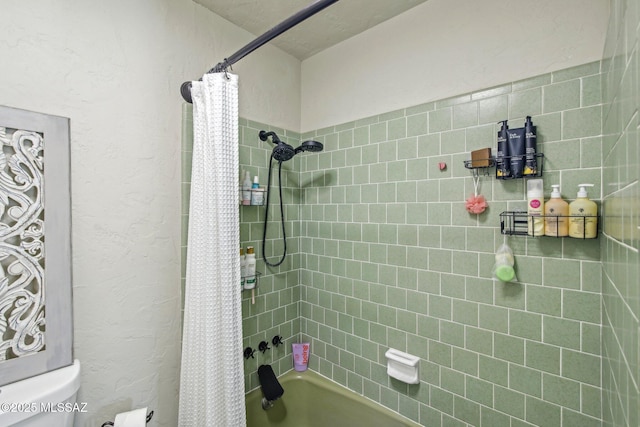 bathroom with a textured wall, toilet, and shower / tub combo with curtain