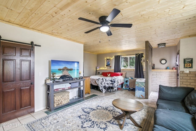 living room with wood ceiling, a barn door, ceiling fan, and tile patterned flooring