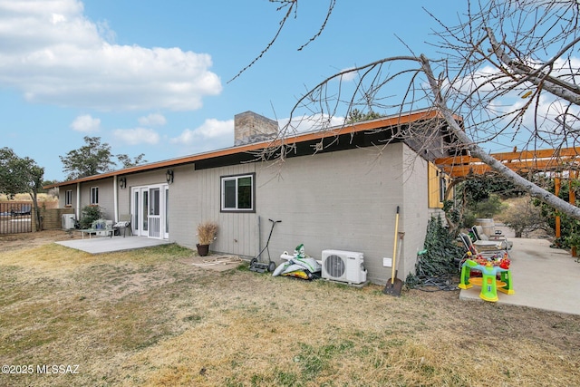 rear view of house featuring a lawn, a patio, a chimney, fence, and ac unit