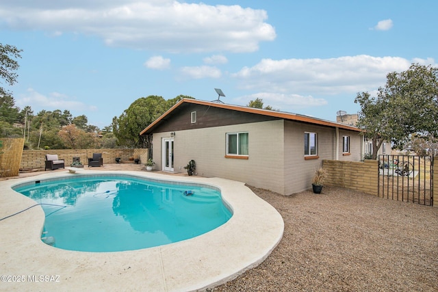 view of swimming pool with a diving board, a patio, fence, and a fenced in pool