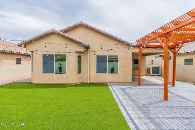 rear view of property with a pergola, a lawn, and a patio