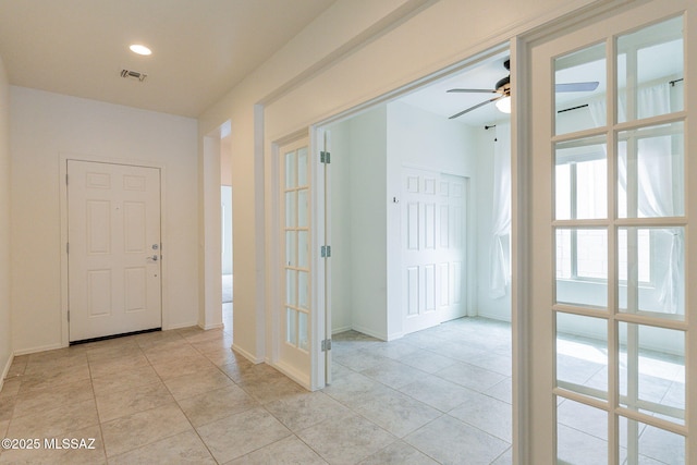 foyer with ceiling fan and light tile patterned flooring