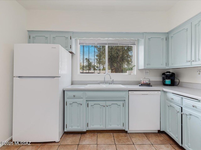 kitchen featuring white appliances, light tile patterned floors, and sink