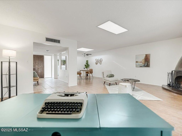 workout room featuring ceiling fan and a wood stove