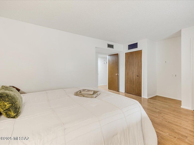 bedroom featuring a textured ceiling and hardwood / wood-style flooring