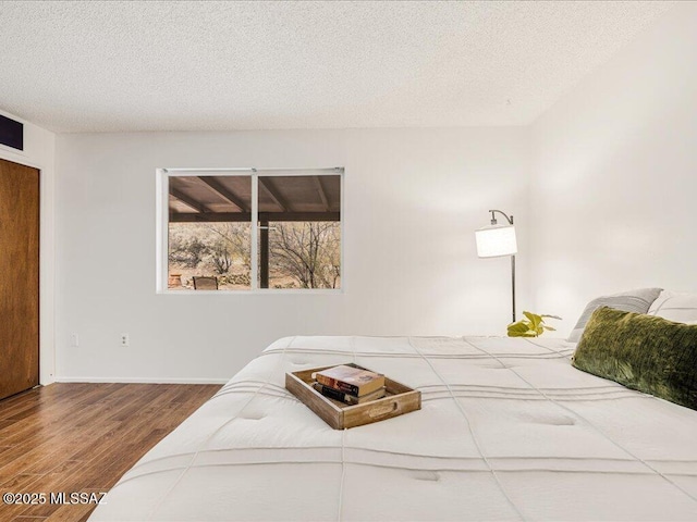 bedroom featuring a textured ceiling and wood-type flooring