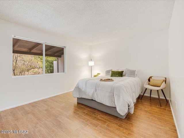 bedroom featuring a textured ceiling and light wood-type flooring