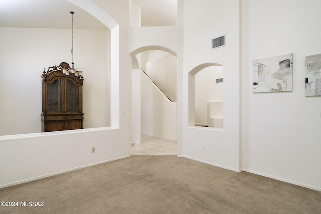 interior space with a towering ceiling and light colored carpet