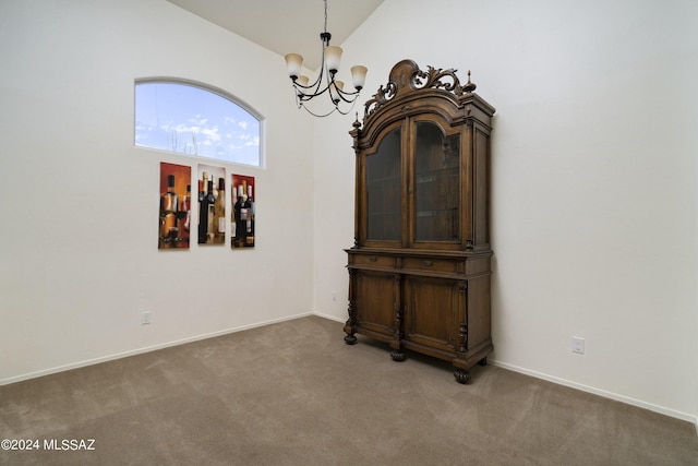 empty room featuring carpet flooring, a chandelier, and lofted ceiling