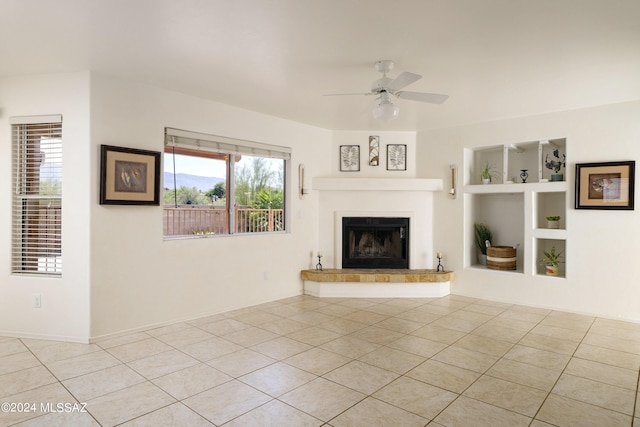 unfurnished living room featuring ceiling fan, light tile patterned flooring, and built in features