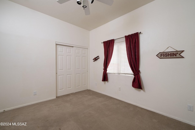 carpeted spare room featuring ceiling fan