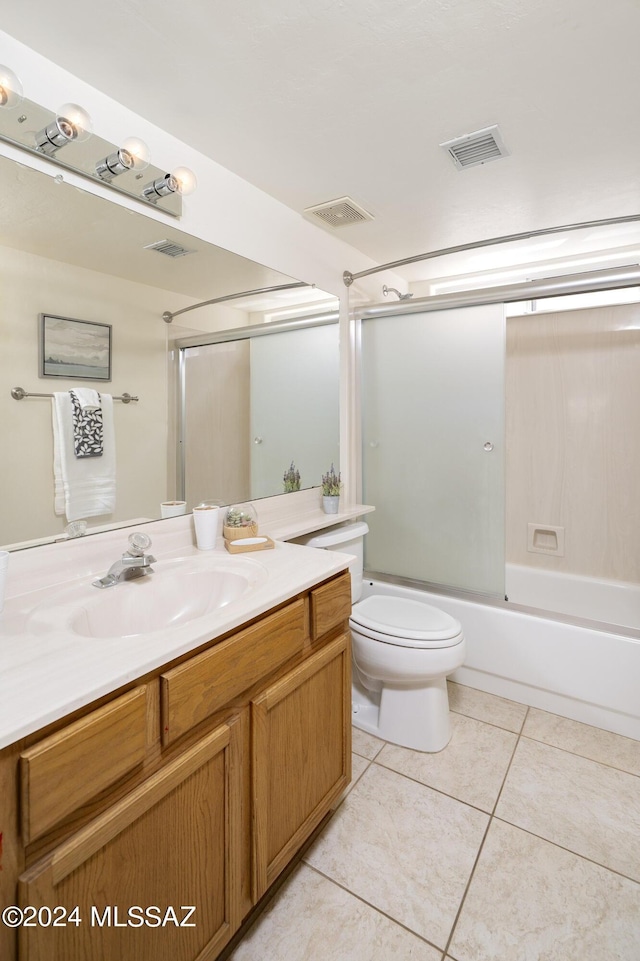 full bathroom with tile patterned floors, vanity, bath / shower combo with glass door, and toilet