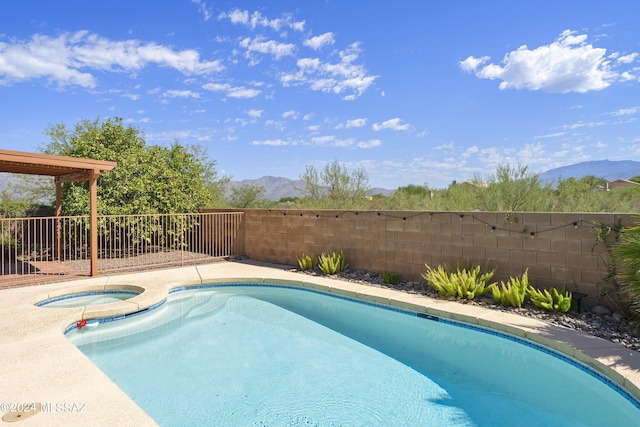 view of pool featuring an in ground hot tub and a mountain view