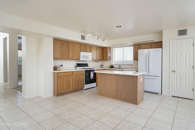 kitchen featuring light tile patterned flooring, white appliances, a kitchen island, and sink