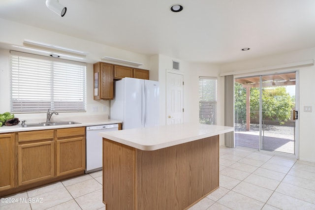 kitchen featuring sink, a kitchen island, white appliances, and light tile patterned floors