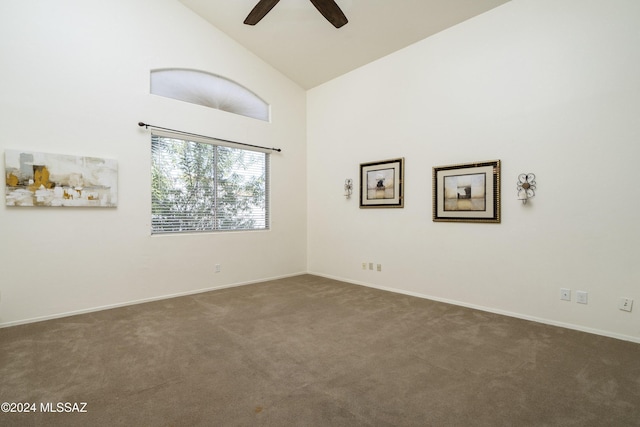 carpeted spare room featuring ceiling fan and high vaulted ceiling