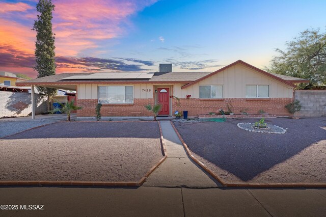 ranch-style house featuring solar panels