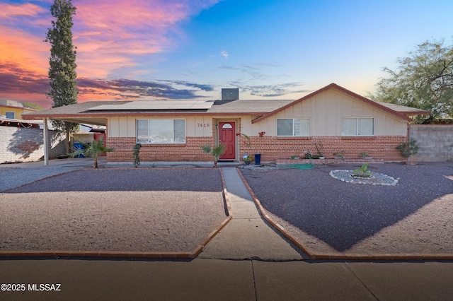 ranch-style house featuring solar panels