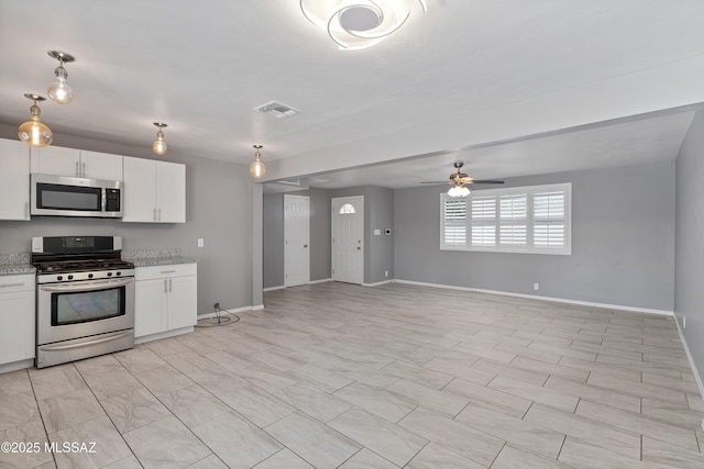 kitchen with white cabinets, ceiling fan, light stone counters, and stainless steel appliances