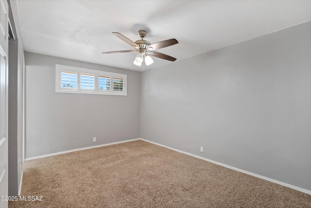 empty room featuring ceiling fan and carpet