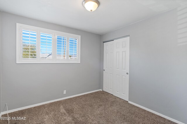 unfurnished bedroom featuring carpet floors and a closet