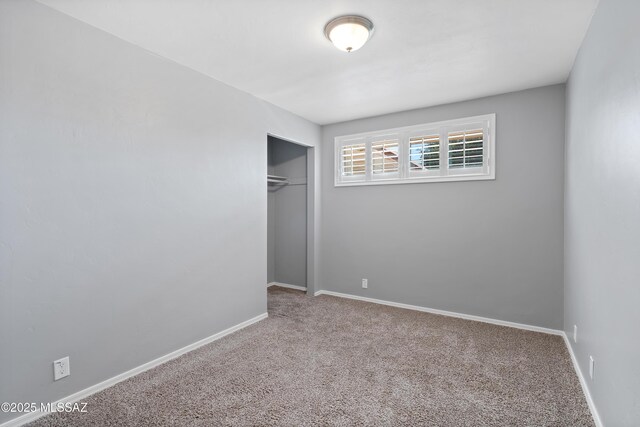 unfurnished bedroom featuring carpet and a closet