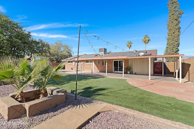 rear view of house with a lawn and a patio area