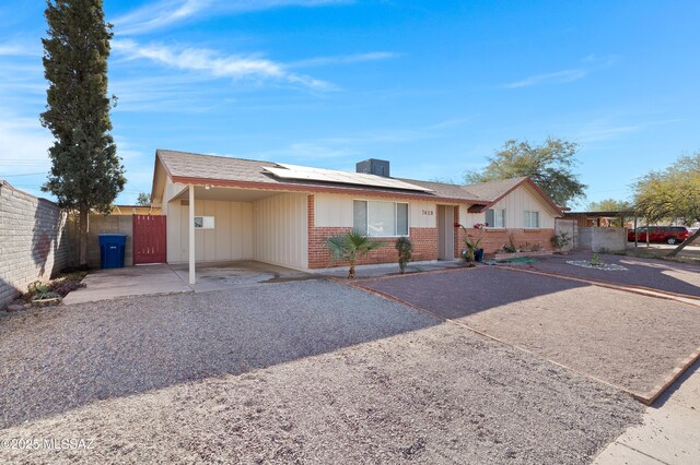 ranch-style house featuring solar panels