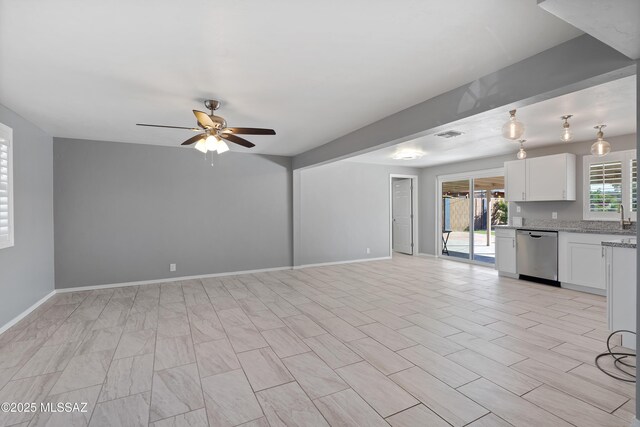 unfurnished living room with ceiling fan and sink